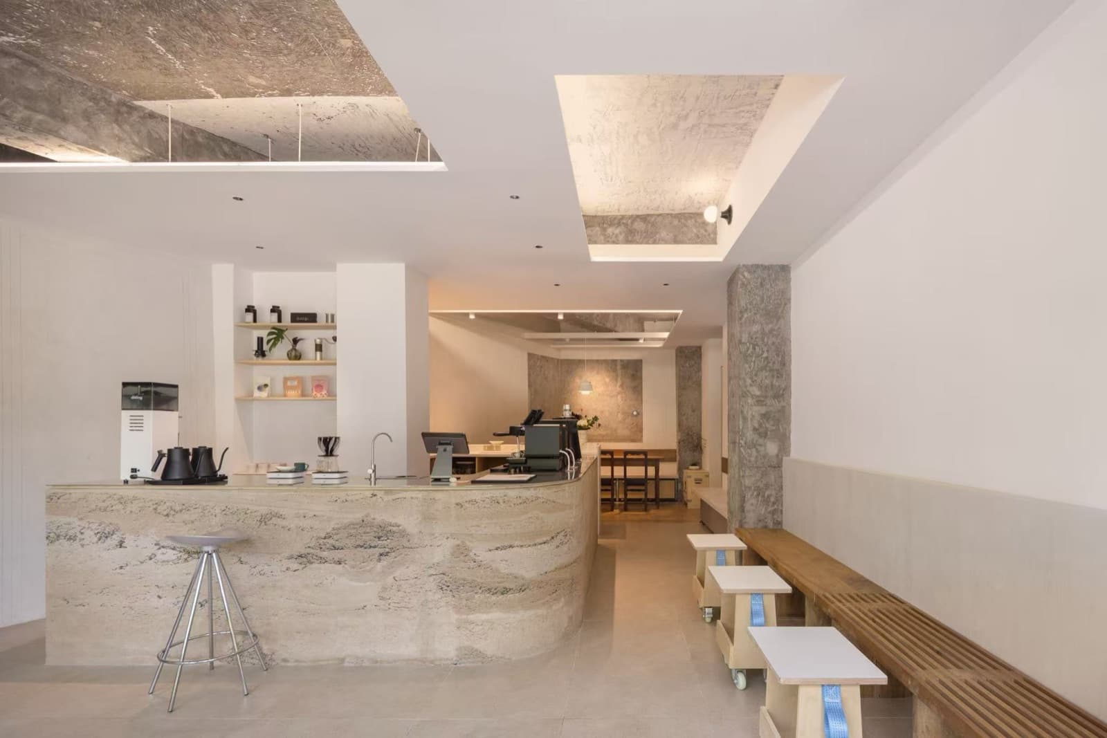 The bar seen from the door, with grinder and kettles on top and a bench on the right