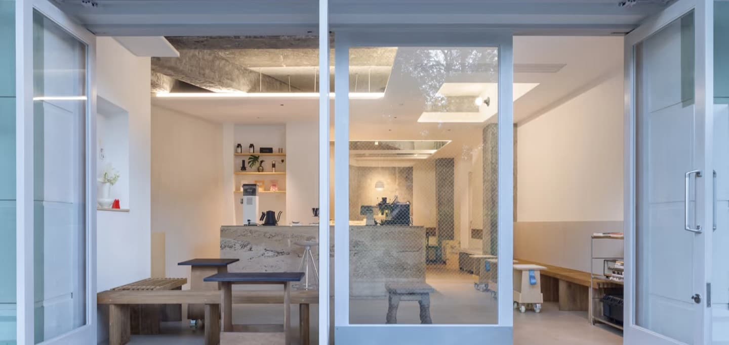 Facing the open doors — window bench, small tables and the bar